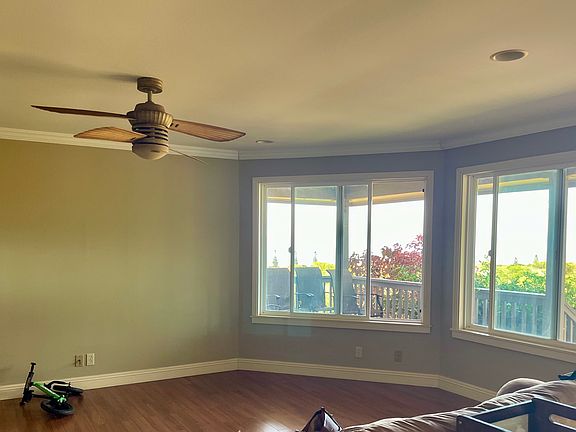 Living room with large windows looking out over pasture with ocean view