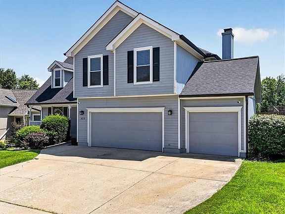 Contemporary two-story residence with light blue siding and a dark gray shingle roof