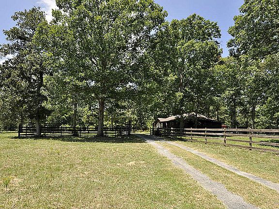 View of entrance to mostly all wood fence surrounding the 1.39 acres which includes the house, garage & extra living quarters/hobby room, RV storage, & barn.