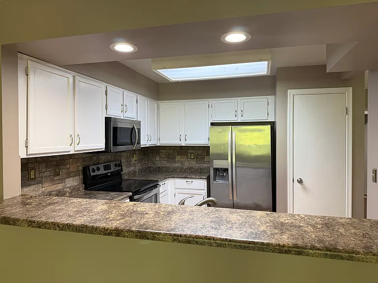Kitchen with counter bar and large pantry.