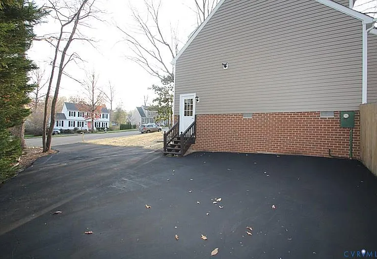 Expansive, double width driveway w/ pedestrian door leading to mud room