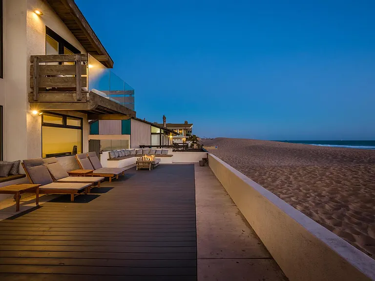 Front deck with firepit and chaise loungers on beach