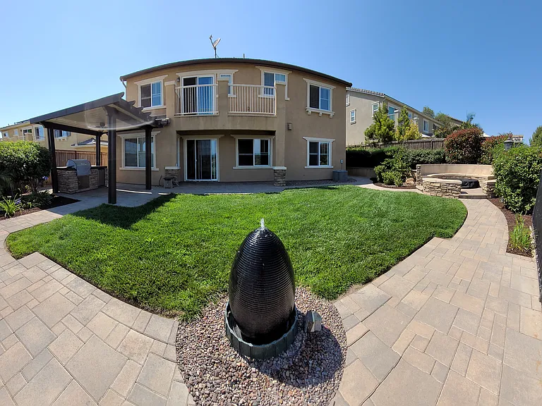 Professionally Landscaped Home with Custom Gas Firepit and Sitting Area, Gazebo with Built-in BBQ/Frig and Fan Viewed from backyard