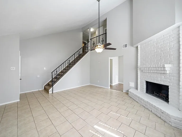 living room with vaulted ceiling leading to upstairs.