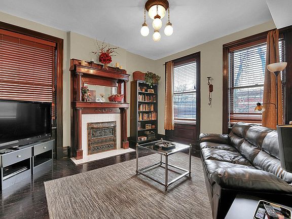 Living Room - original fireplace and woodwork, painstakingly salvaged wood floors, venetian blinds