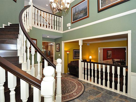 Dramatic 2-story foyer with grand curved staircase.
