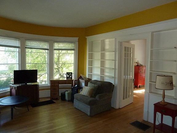 Living room looking NE at Bay window, built-in book cases, and BR.