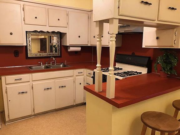 Cheerful kitchen with gas stove and snack bar.