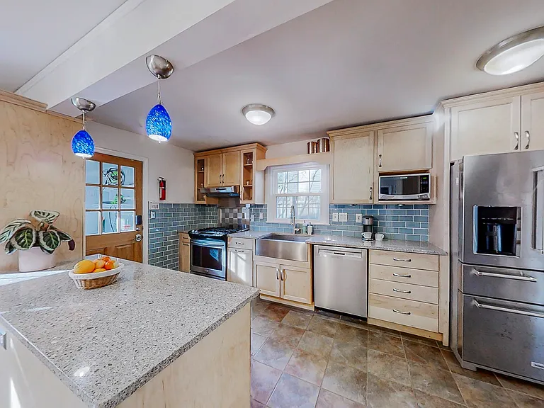 Fully equipped kitchen with stove, dishwasher, microwave, coffee pot, refrigerator, and garbage disposal.