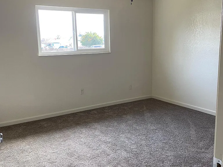 Primary bedroom with fan and closet, includes small in-suite bathroom