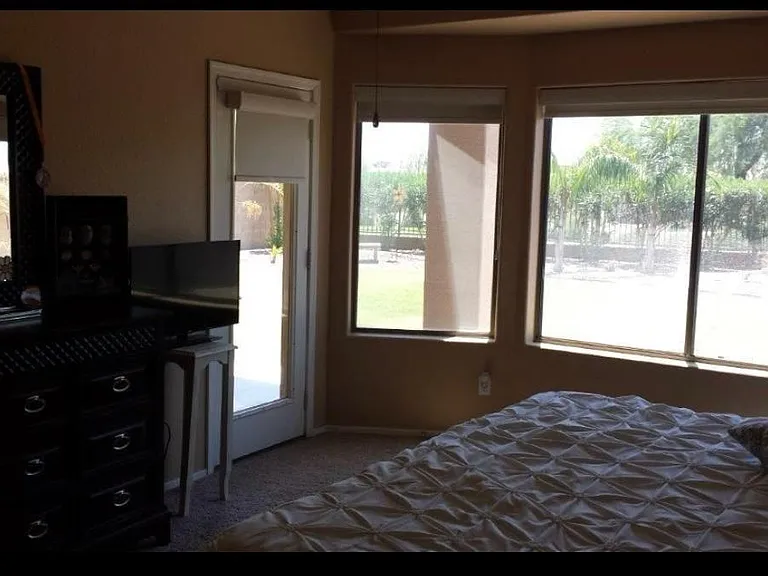 master bedroom with bay window and access to patio and private bathroom and walk in closet and toilet room, on first floor