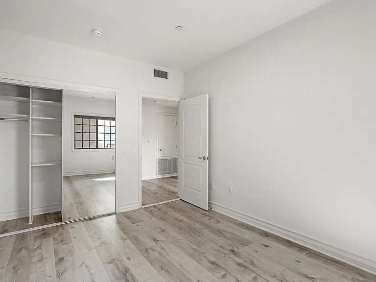 Bedroom with Closet with a Built-In Organization System and Vinyl Flooring