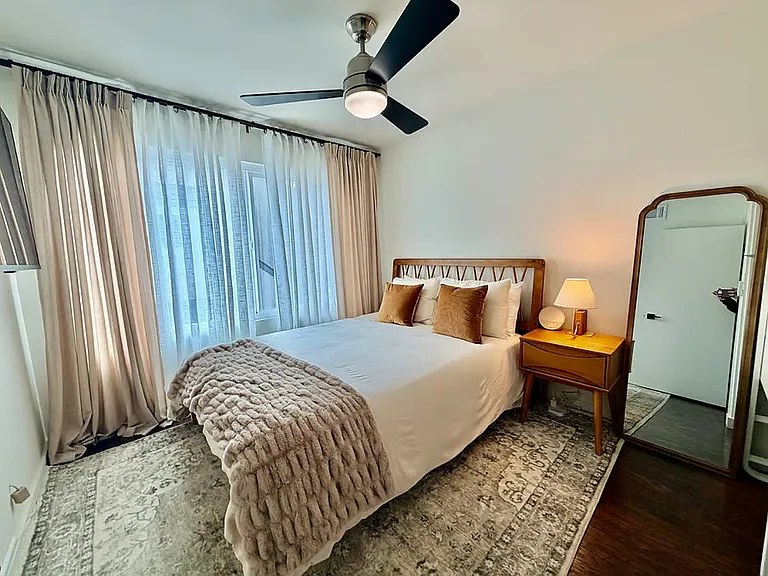 Second bedroom. Spacious, thoughtfully furnished bedroom with cozy textures and plenty of natural light for a relaxing home environment.