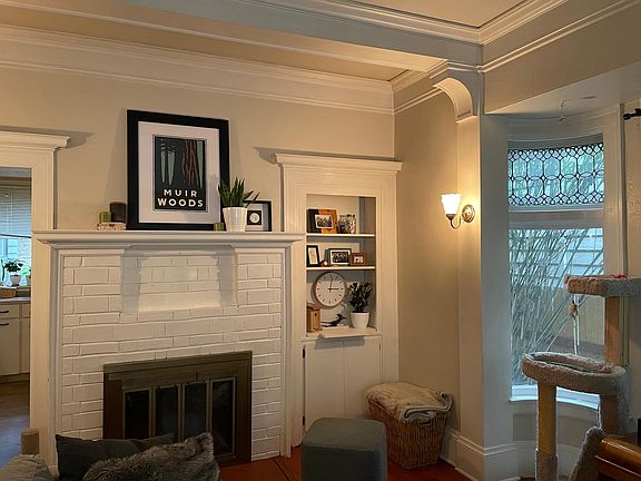 Living room with working fireplace, high ceilings and built-in cabinetry