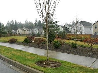 facing the front (is a small park with benches)