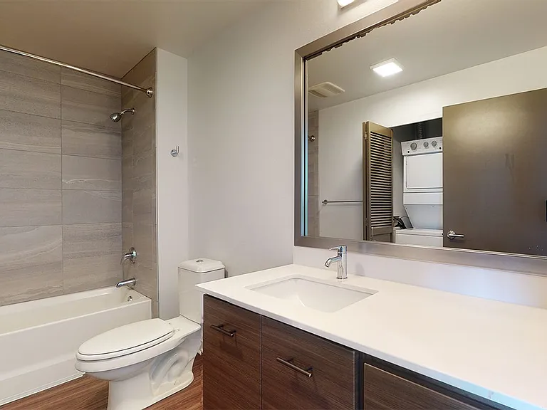 Apartment bathroom with wood-style flooring.