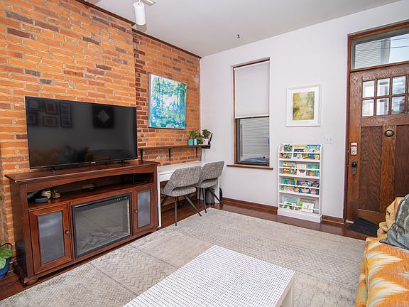 Living room, 2 large windows, exposed brick, open to staircase