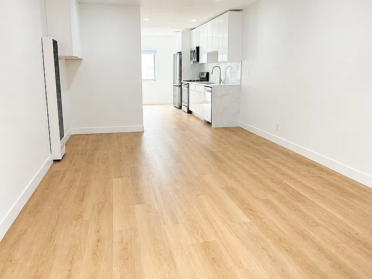 Open living area with modern finishes, recessed lighting, ceiling fan, and light wood-style flooring.