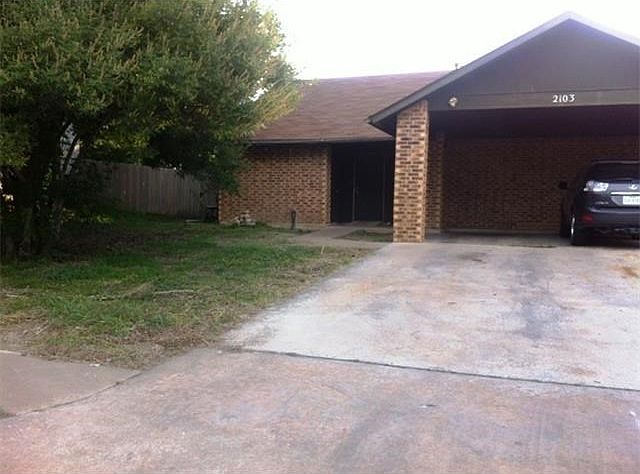 Single story duplex home with one covered carport.