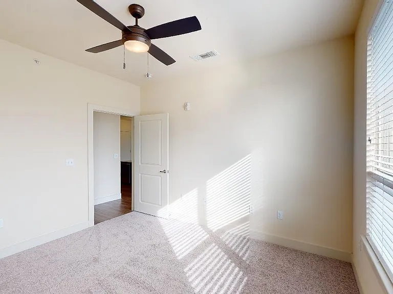 Spacious apartment bedroom with plush carpet flooring