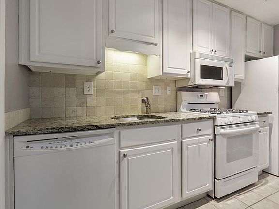 Kitchen with Granite counter and tile backsplash