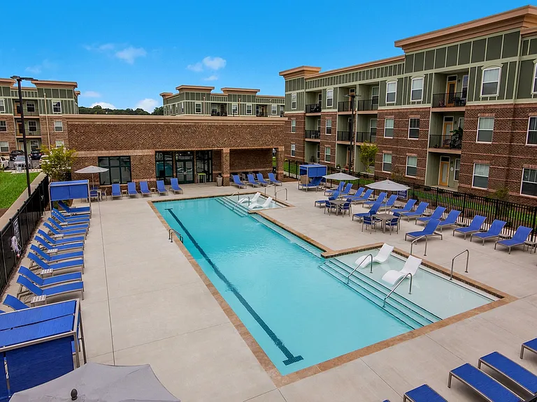 Resort-Style Swimming Pool with Sun Shelf and Fountains During the Day