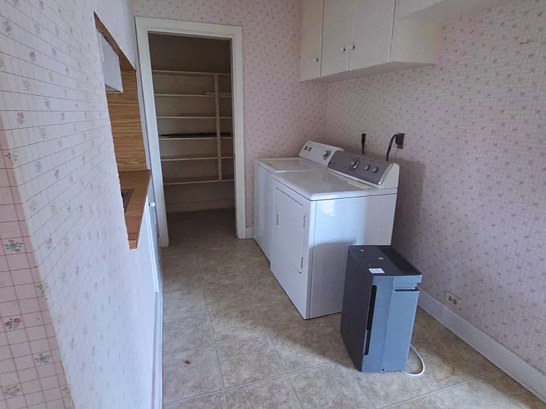 Laundry area with washer, dryer, and built-in storage cabinets