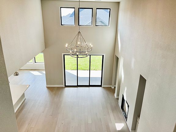 Two story family room with large windows and open to kitchen