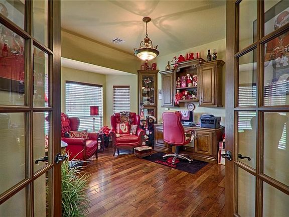Office/Study with built in desk and cabinets. features wood floors and French doors