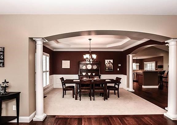 Open and expansive formal dining room stars wainscoting & crown molding.