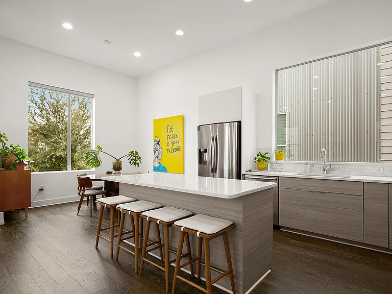 The spacious kitchen features a large center island, refrigerator, dishwasher, microwave, and oven, with plenty of room for cooking, gathering, and entertaining