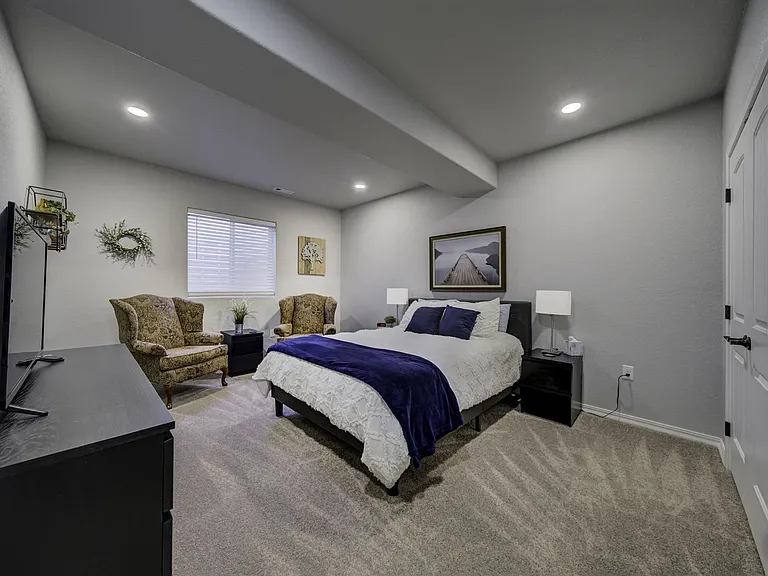 Queen Bedroom
Downstairs bedroom with queen bed, smart TV, two armchairs, dresser, and closet