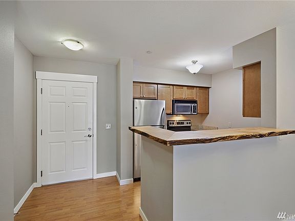 The front door opens into the foyer which is adjacent to the kitchen which is embellished with the rough edged natural wood counter on the island bar!