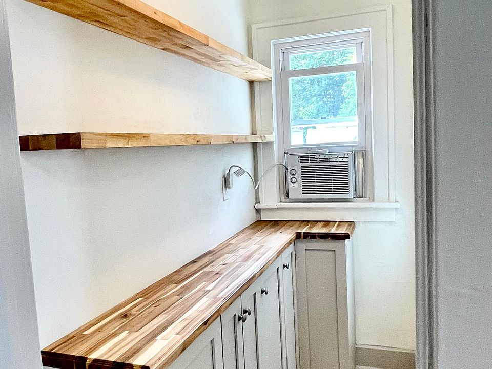 Your very own walk-in pantry just off the kitchen with MORE solid wood cabinetry, butcher block counter, and floating shelving