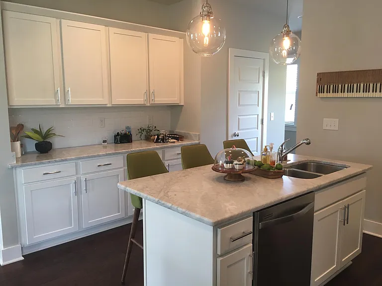 Kitchen island with sink, dishwasher, and seating.