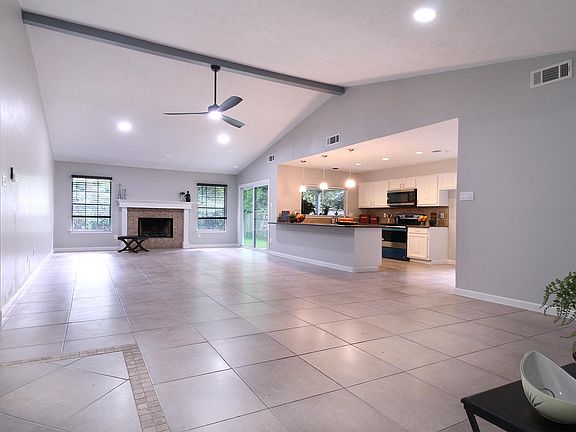 View of the open-floor plan from the front door. Check out the high ceiling with recess lighting and a propeller fan. Tile throughout for easy maintenance.