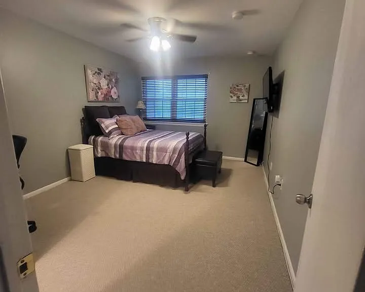 Spacious and fully furnished bedroom with ceiling fan.