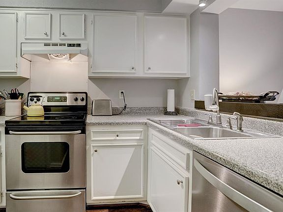 Stainless appliances, soft grey tones makes for a kitchen that you can do gourmet or warm up your take out