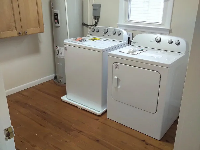 Utility room with washer dryer, hot water heater, extra storage cabinets and extra closet