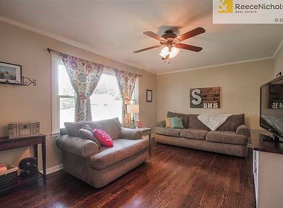 Beautiful hardwoods throughout, including in this living room with crown molding and fresh interior paint