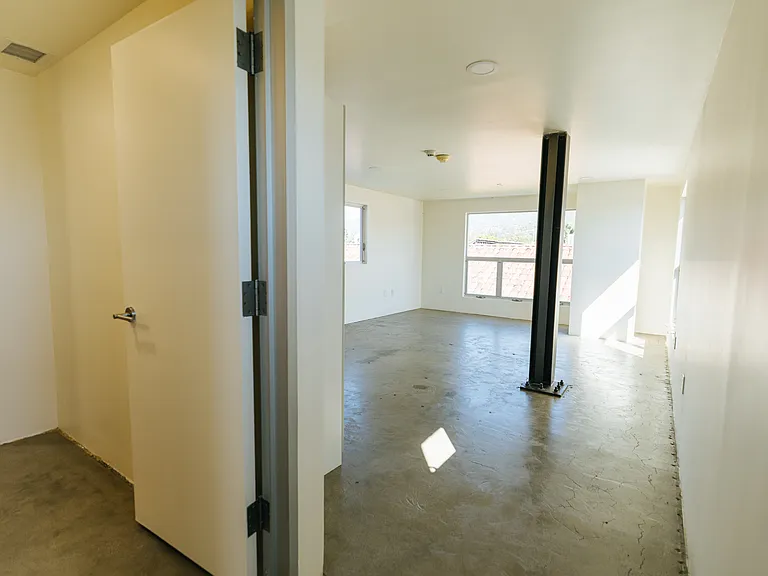 View from the top of the stairs entering the second floor. Private bathroom to the left, living and bedroom straight ahead.