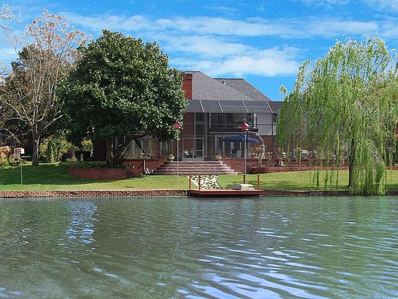 "Incredible" is an apt description for this setting.  Fully bulk-headed, the home sits up high overlooking the lake while the Pool is set behind an attractive bricked retaining wall and underneath a massive screen