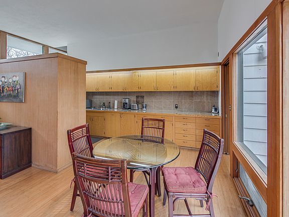 Enjoy that morning coffee while watching the birds in the large backyard,through the wall of windows!This is the eating area.This space is partly open to the kitchen and totally open to the living room