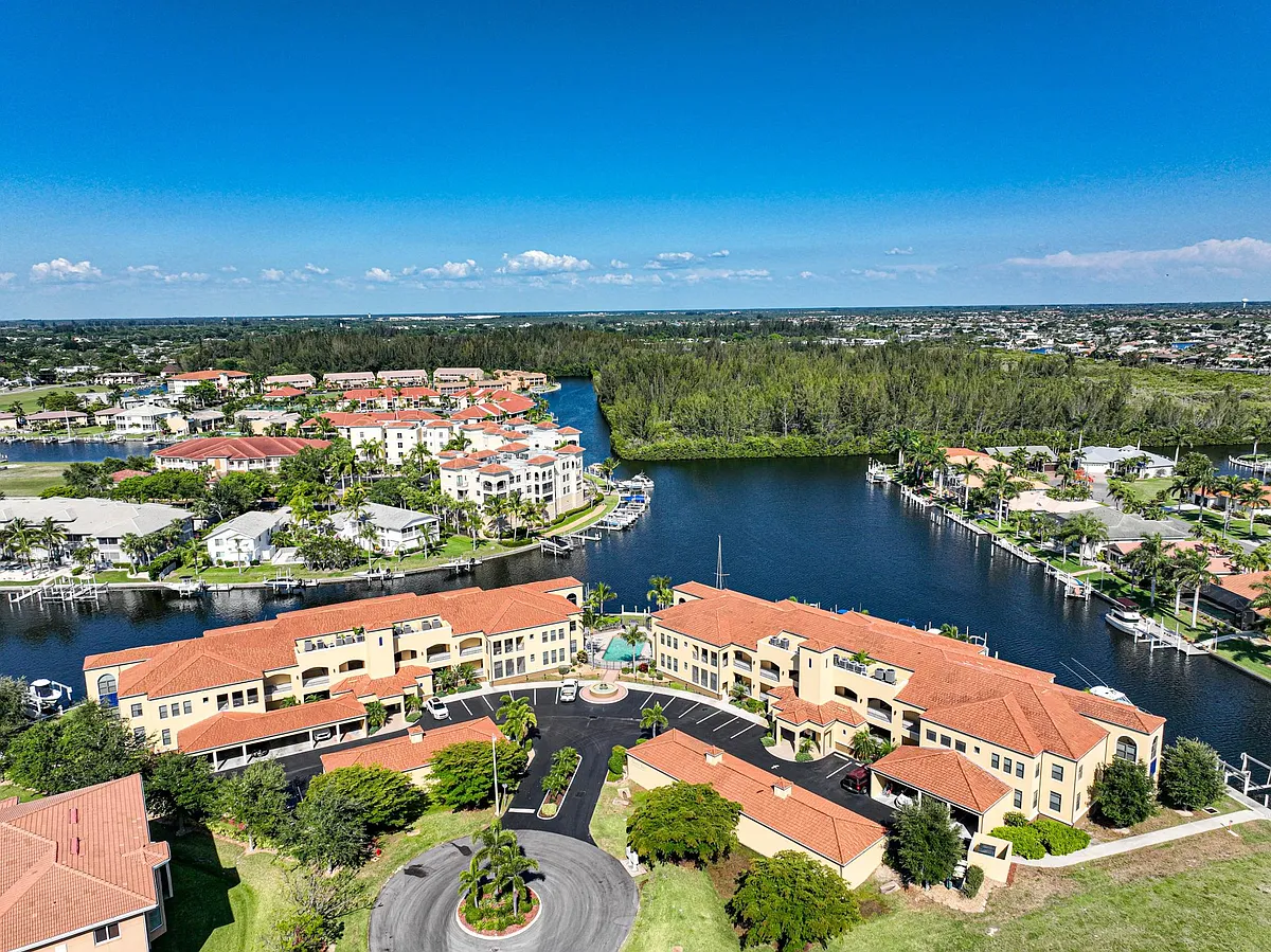 Photo 2 of 32 - 3334 Purple Martin Dr #116 - Punta Gorda, FL Aerial from west looking east at entrance drive and turning basin beyond. Deep water canals lead out to Charlotte Harbor and the Gulf. - 3334 Purple Martin Dr #116