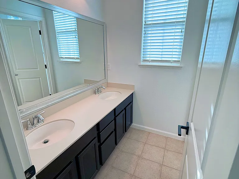 Bathroom with double sink, shower over bathtub