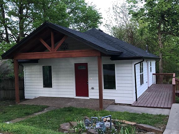 Front yard with covered porch. Side deck with door entry into kitchen.