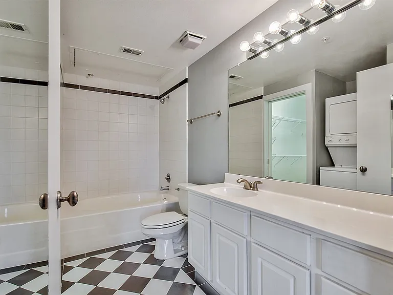 Bathroom featuring a white vanity with extensive counter space and under-sink cabinetry