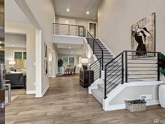 Grand two-story entry foyer framed by an open metal staircase railing. True contemporary design elements throughout this beautiful Chaffey Building Group home. Fabulous great room design with the benefit of a formal dining room.