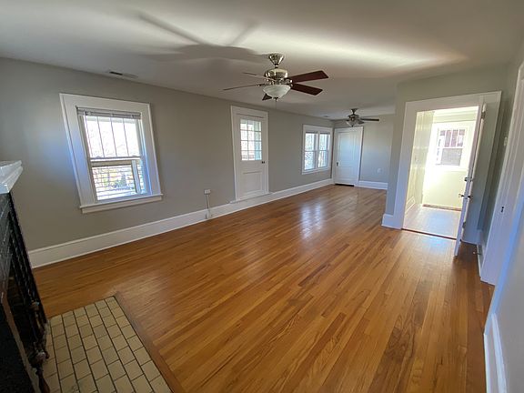 View of living room. Gas fireplace and door to front porch to the left; door to steps on the right