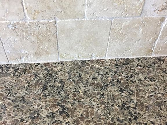 Kitchen granite and travertine back splash 